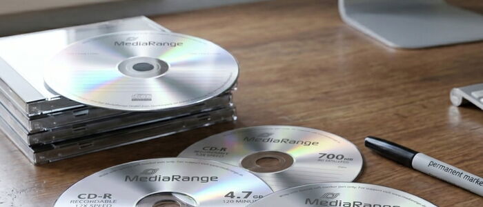 Mehrere CD Rohlinge auf einem Tisch, ein Stift der zur CD Beschriftung da ist